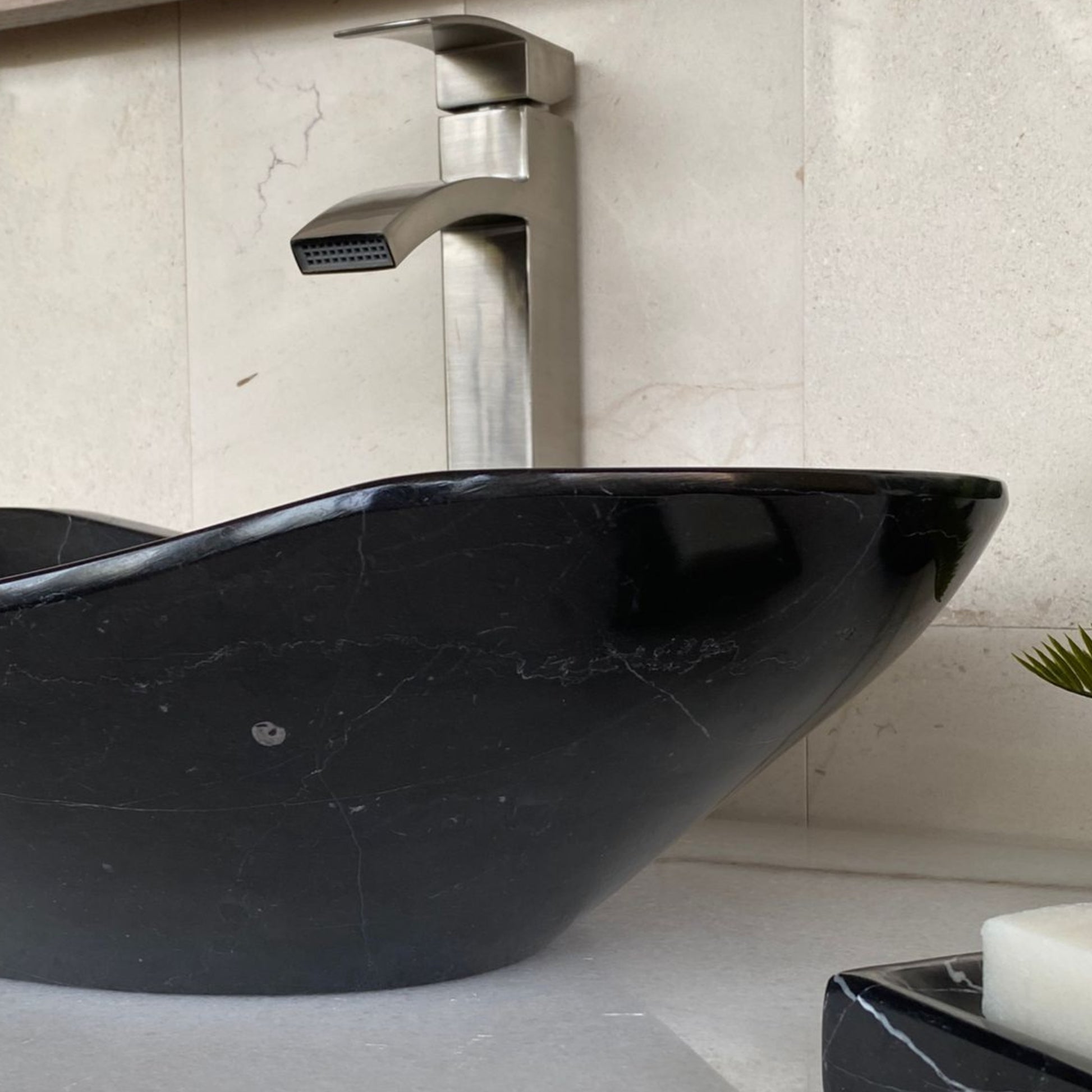 Side profile of handcrafted black marble oval vessel sink featuring elegant sculpted silhouette, polished marble finish, natural stone construction, and luxury modern bathroom vanity styling.