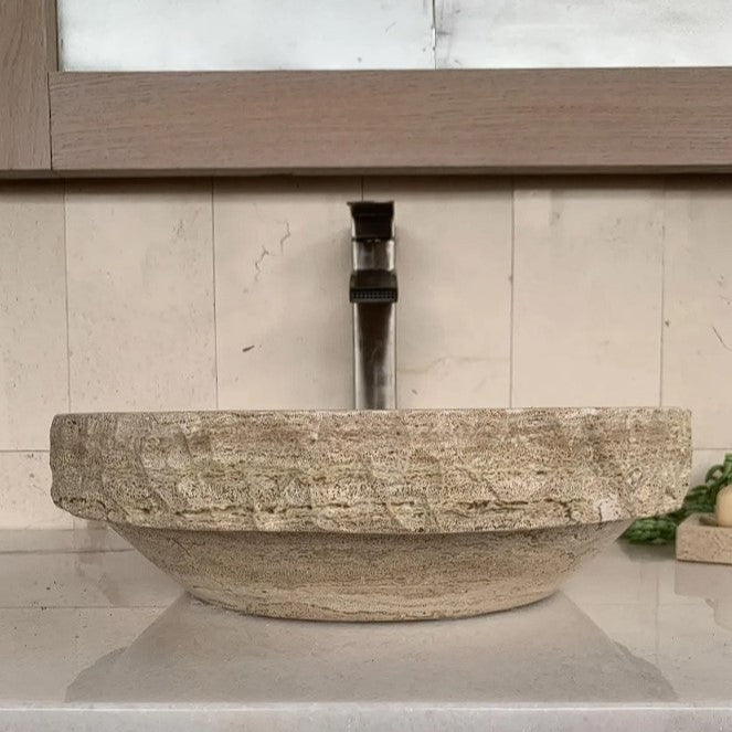 Round tan travertine bathroom basin with chiseled rim