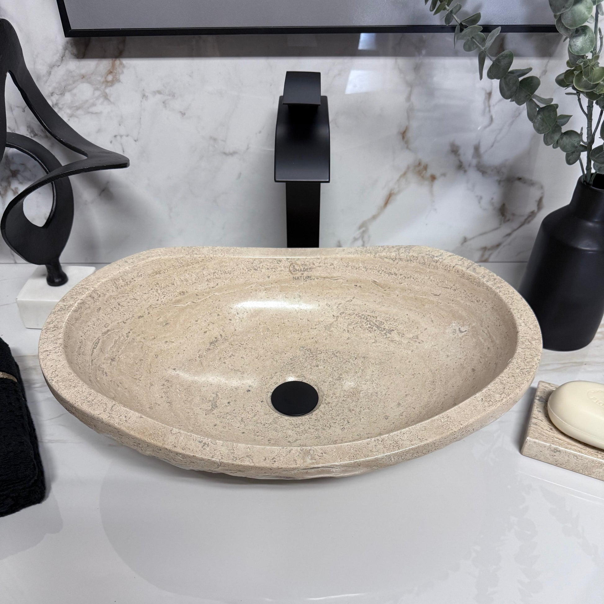 Top-down view of oval travertine wash basin highlighting the smooth polished interior and unique natural stone grain